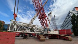 Suuren nosturin osia on työmaalla maassa.