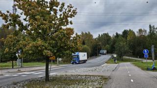 Rekka ajaa alas mäkeä vehreässä puistossa kulkevalla tiellä.