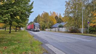 Rekka ajaa asuinkatua pitkiin ruskamaisemassa. 